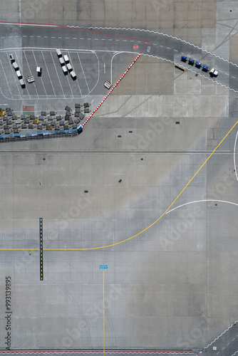 View from above luggage carts and road markings on sunny airport tarmac

