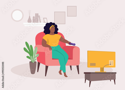 One Plus Size Black Woman With Remote Control Sitting On Sofa Watching TV In The Living Room At Home.