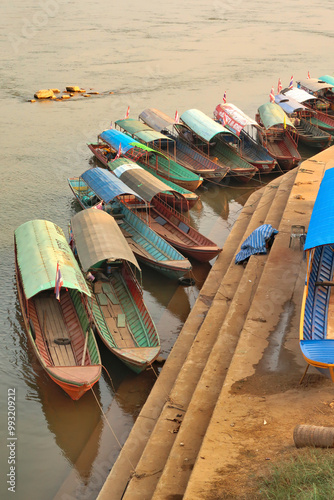 Many colorful, traditional, wooden boats docked at the shore of the Mekong River, Wiang Chiang Kong, Thailand photo