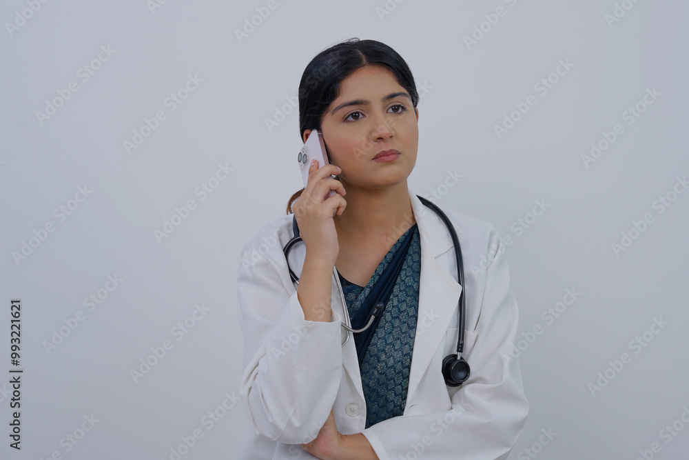 Serious Indian Female Doctor Talking on Phone Call Serious Indian Female Doctor Talking on Phone Call