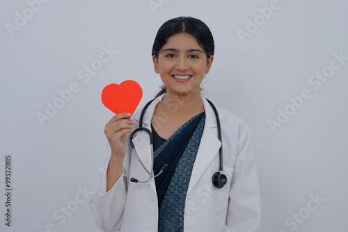 Indian Female Doctor Holding Heart and Smiling at Camera