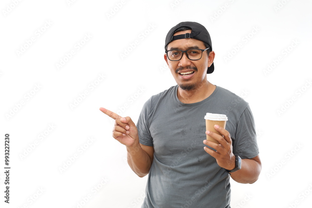 Asian man drinking a cup of hot coffee over white isolated background very happy pointing with hand and finger to the side Asian man drinking a cup of hot coffee over white isolated background very happy pointing with hand and finger to the side