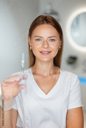 Cute beautiful fresh doctor cosmetologist girl with a smile holds a filler injection in a medical clinic. Cosmetology clinic