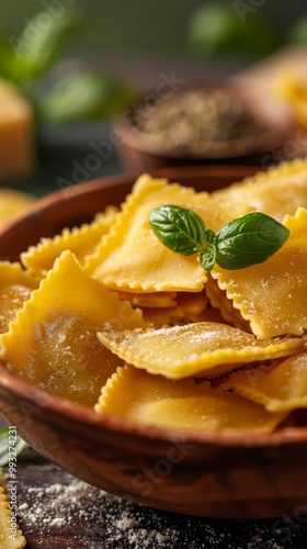 Close-up of cooked ravioli with basil and grated cheese in a wooden bowl.