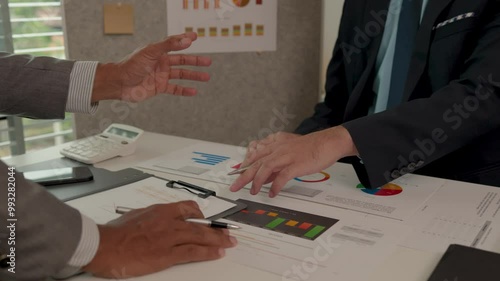Architects and consultants of a housing development are discussing the structure and layout of a house,Two engineers are having a meeting about a problem that has arisen in the blueprints