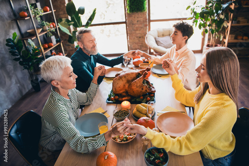 Above view portrait of big full family hold arms pray thanksgiving gathering celebration dinner flat indoors