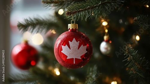 close-up of a red christmas ornament with a white maple leaf hanging from an evergreen tree, symbolizing canadian holiday spirit and national pride, with a blurred background for emphasis photo