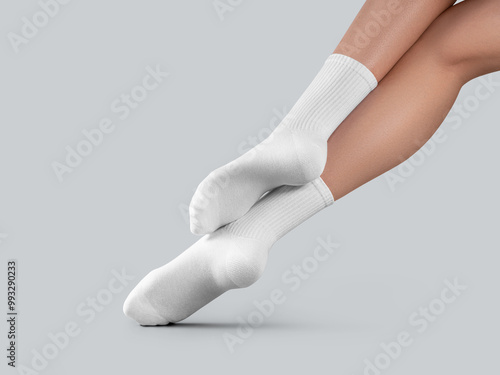 Mockup of white long socks on women's legs, with stretched toes, diagonal presentation, back view, isolated on background. photo