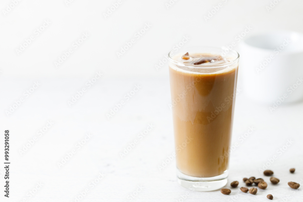 Ice coffee in a tall glass with milk on white marble table. Ice coffee in a tall glass with milk on white marble table.