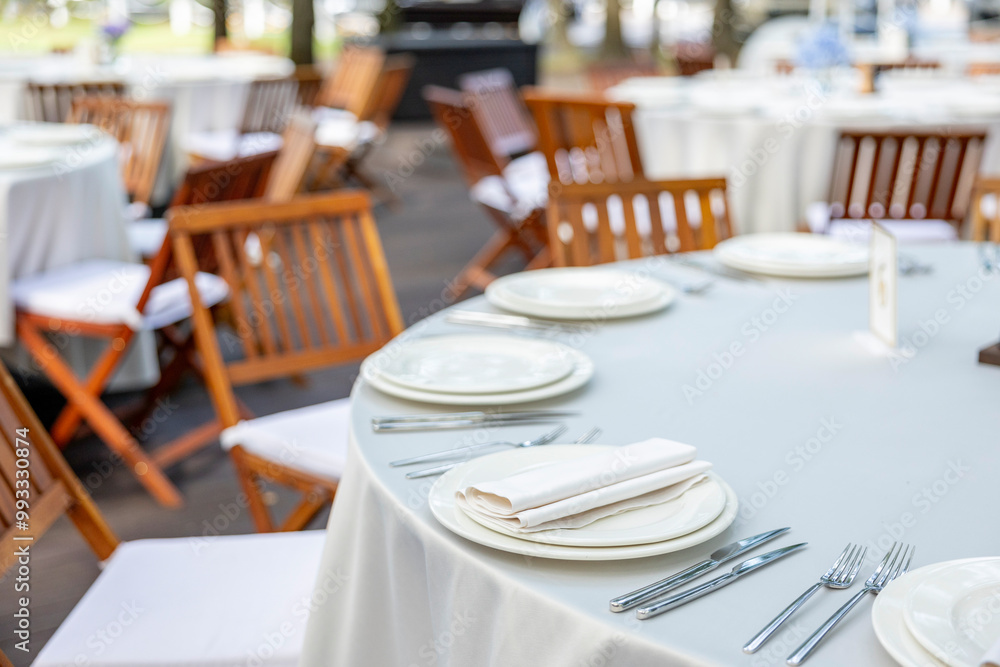 Beautifully organized event - round served table banquet ready for guests, round decorated table with empty plate, glasses, forks, napkin. Beautifully organized event - round served table banquet ready for guests, round decorated table with empty plate, glasses, forks, napkin.