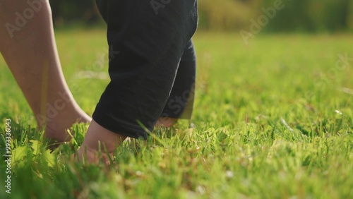 Mom and baby taking the first steps. Walk child toddler concept. A baby is studying with her feet bared. Mom and baby barefoot studying the first steps. concept care motherhood lifestyle.