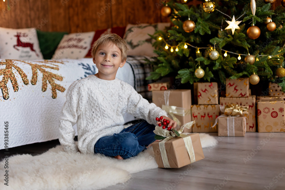 Sweet blond child, cute boy, playing with christmas toys on Christmas, beautifully decorated home for Christmas, cosy place Sweet blond child, cute boy, playing with christmas toys on Christmas, beautifully decorated home for Christmas, cosy place