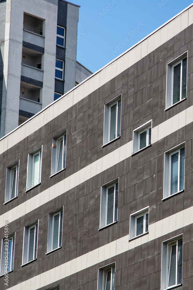 A tall building with large windows against a bright blue sky A tall building with large windows against a bright blue sky