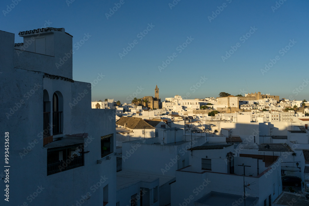 Fototapeta premium Panoramic view of the white beautiful village of Vejer de la Frontera Divino and the Salvador church in the background at sunset, Cadiz province, Andalusia, Spain