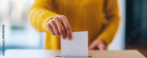 Person voting with ballot in a ballot box