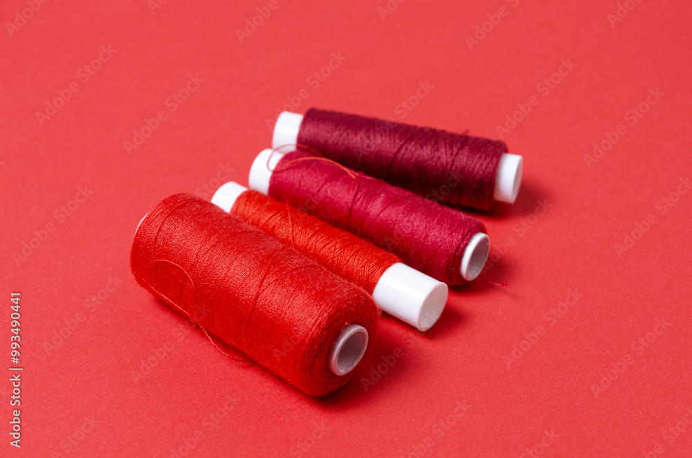 Top view of thread spools on red background Top view of thread spools on red background