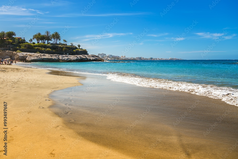 The gentle waves of Playa Del Duque in Tenerife reflect shades of turquoise and blue The gentle waves of Playa Del Duque in Tenerife reflect shades of turquoise and blue