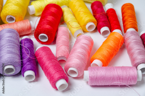 Top view of many colorful thread spools background