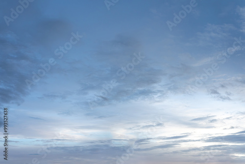 Dramatic cloudscape of white fluffy clouds against a deep blue sky, illuminated by the warm light of the setting sun