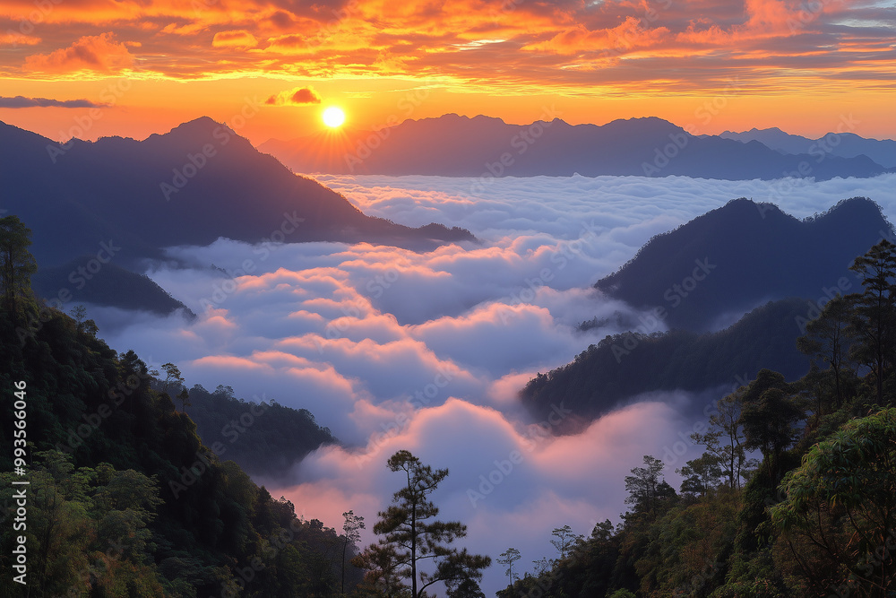 Obraz premium sea of clouds at sunrise over mountain valley with colorful orange sky