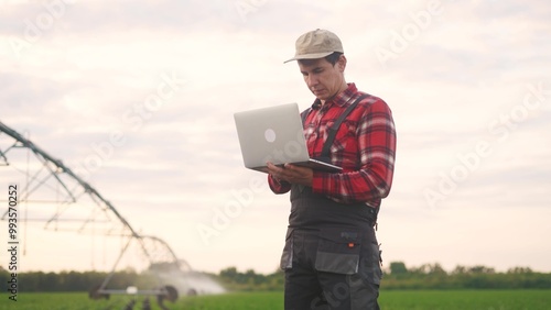irrigation agriculture. a male farmer works on a laptop in a field with corn lifestyle. irrigation agriculture business concept. farmer scientist studying corn . healthy natural foods concept
