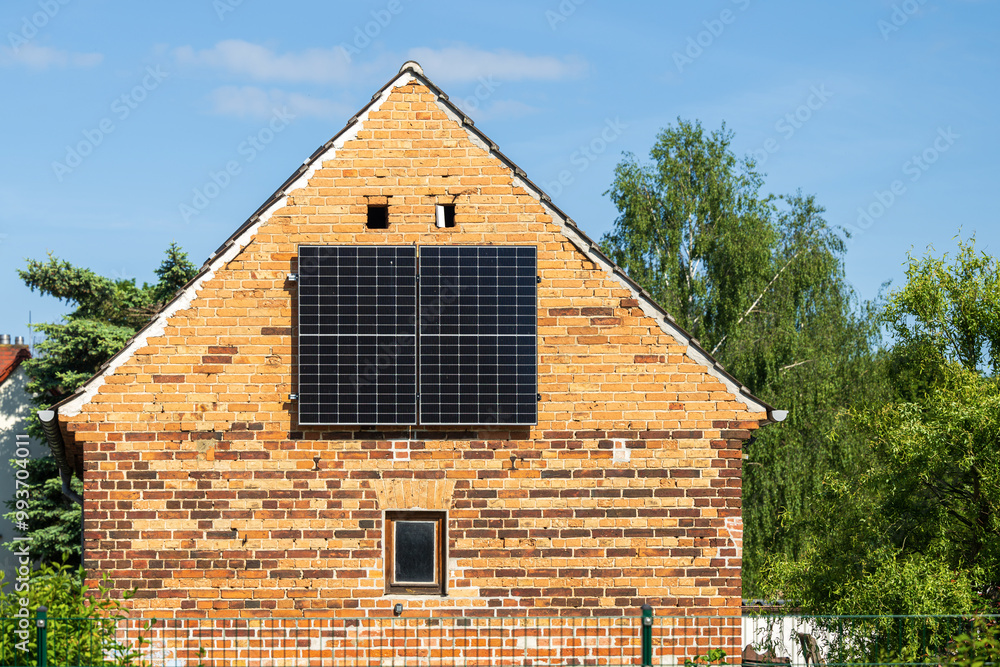 Eine kleine Solaranlage am Giebel eines alten Hauses