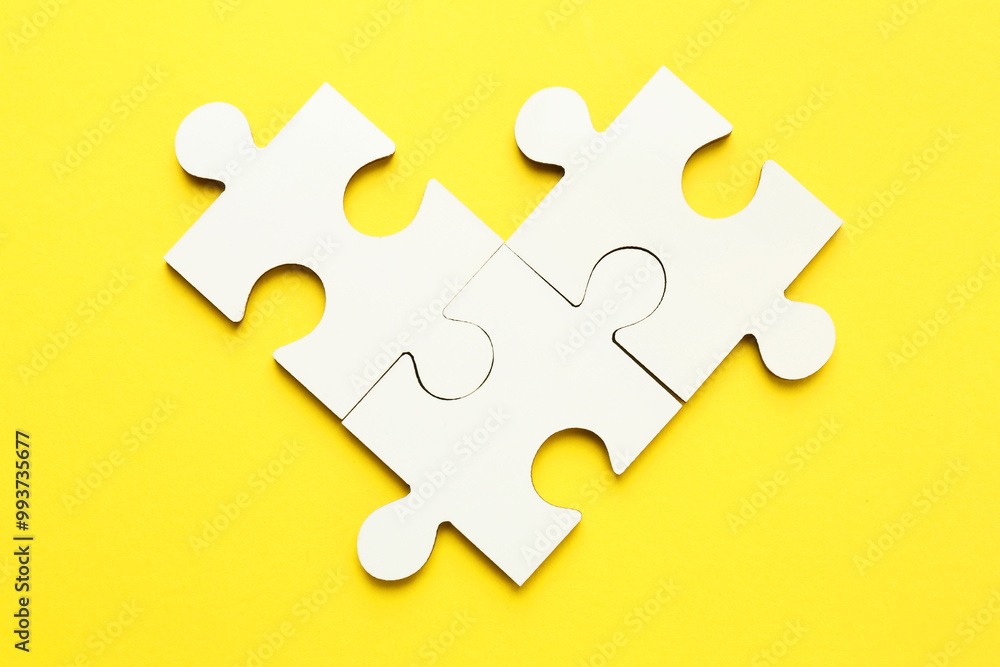 White puzzle pieces on yellow background, top view White puzzle pieces on yellow background, top view