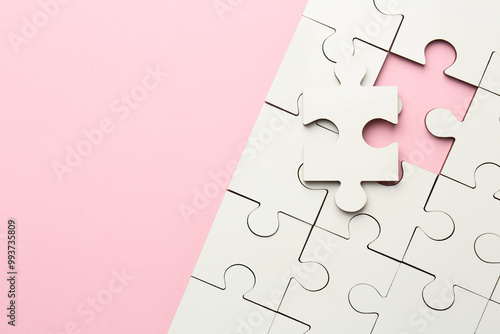 White puzzle pieces on pink background, top view. Space for text