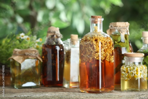 Different natural tinctures on wooden table outdoors, closeup photo