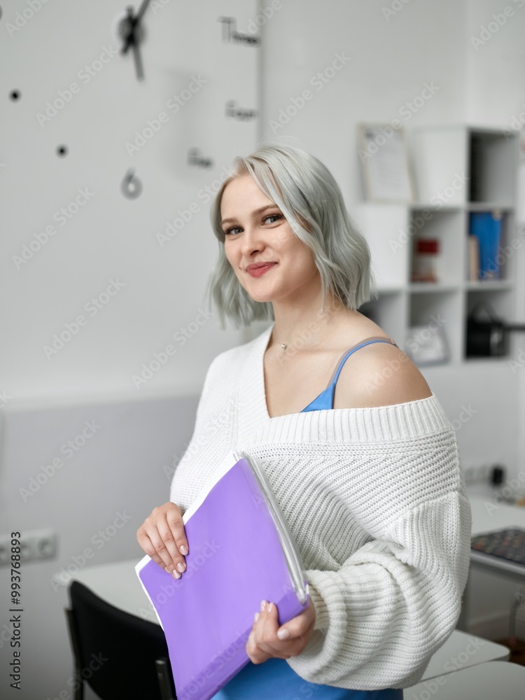 Photo of a beautiful female English teacher working at school holding a notepad, isolated on white board background Photo of a beautiful female English teacher working at school holding a notepad, isolated on white board background