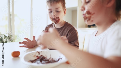 baby boy and girl eat chocolate. dirty little baby kids in the kitchen eating chocolate in lifestyle the morning. happy family eating sweets kid dream concept. baby dirty face eating chocolate cocoa