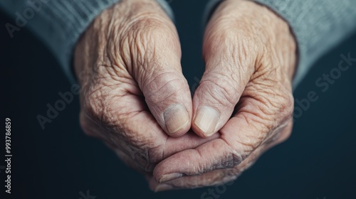 A close-up of an elderly person's hands held together showcasing the beauty of aging. The detailed creases and textures symbolize years of life and wisdom. photo