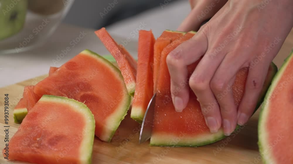 Hands of young woman european cuts watermelon into slices with kitchen knife on cutting board, right side view close up. Healthy lifestyle concept, raw food diet, cooking at home, refreshing Hands of young woman european cuts watermelon into slices with kitchen knife on cutting board, right side view close up. Healthy lifestyle concept, raw food diet, cooking at home, refreshing