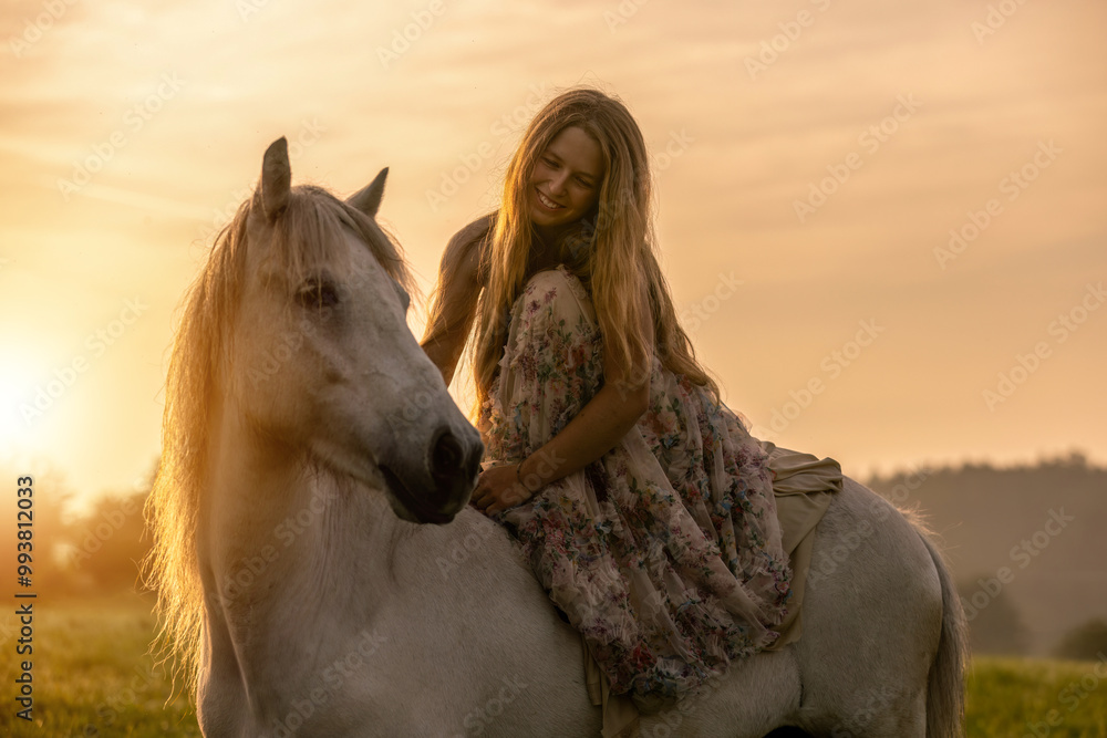 Obraz premium Romantic horsemanship portrait: A young woman and her icelandic horses interacting together in front of a beautiful sunrise landscape