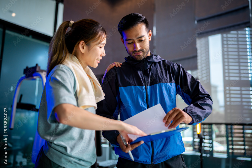 Asian man and woman working out, one is a trainer, the other is an exerciser Asian man and woman working out, one is a trainer, the other is an exerciser
