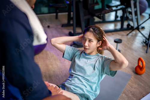 Asian man and woman working out, one is a trainer, the other is an exerciser