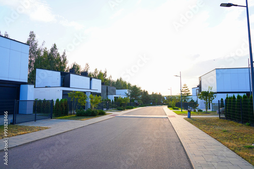 Modern luxury Villa. Street Road in Contemporary Residence. Modern Prefab house. Prefabricated home with lawn, shrubs, green courtyard in sustainable enviroment. Family House in Gated Community. Villa