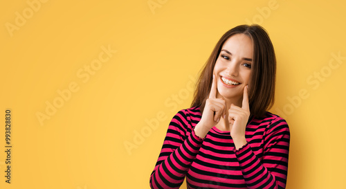 Dental dent health ad concept image - brunette beautiful woman wear casual cloth show point fingers white toothy smile mouth. Portrait of happy girl, isolate yellow background, wide banner composition