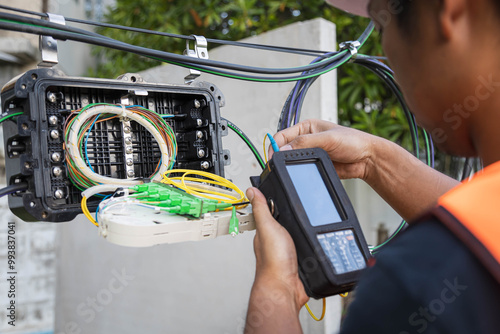 Engineer or technician checking fiber optic cables in internet splitter box.Fiber to the home equipment. FTTH internet fiber optics cables and cabinet..