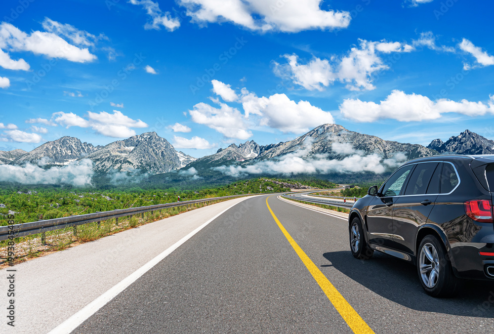 The car is driving along the highway surrounded by picturesque nature.
