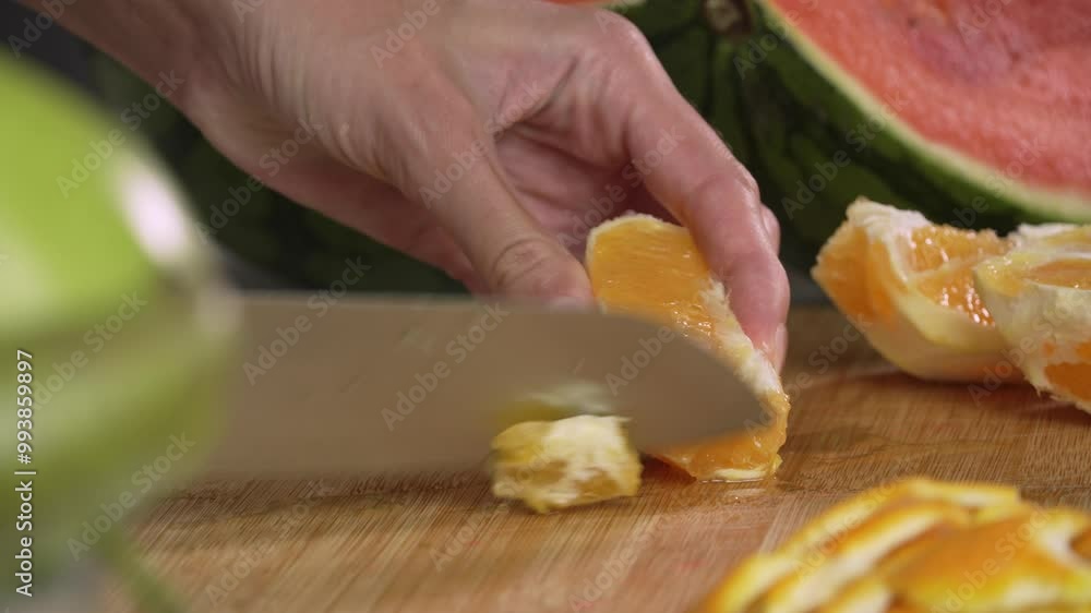 Hands of young woman european cutting orange with kitchen knife for making fruit salad, left side view close up. Healthy lifestyle concept, raw food diet, cooking at home, refreshing Hands of young woman european cutting orange with kitchen knife for making fruit salad, left side view close up. Healthy lifestyle concept, raw food diet, cooking at home, refreshing