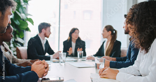 Tablou pe pânză Charming Asian female in business suit Consulting with team in defocus background