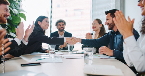 Ending of team meeting in business company. People in official clothing. Everyone shaking hands and clapping. Positive ending to discussion. Celebrating positive development. Concept of success.