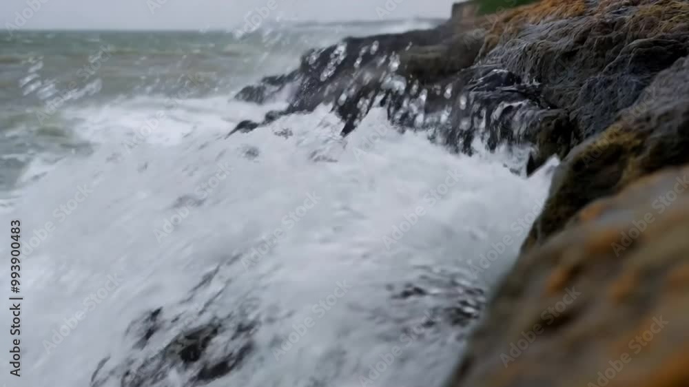Close-up video of powerful ocean waves crashing against jagged rocks on a windy day. Slow-motion spray creates a dramatic cinematic effect. Generative AI Close-up video of powerful ocean waves crashing against jagged rocks on a windy day. Slow-motion spray creates a dramatic cinematic effect. Generative AI