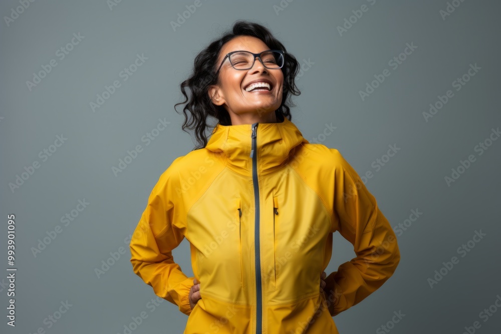 Portrait of a joyful indian woman in her 40s wearing a windproof softshell in minimalist or empty room background Portrait of a joyful indian woman in her 40s wearing a windproof softshell in minimalist or empty room background