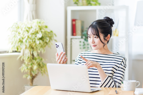 リビングでテレワークをする若い女性。