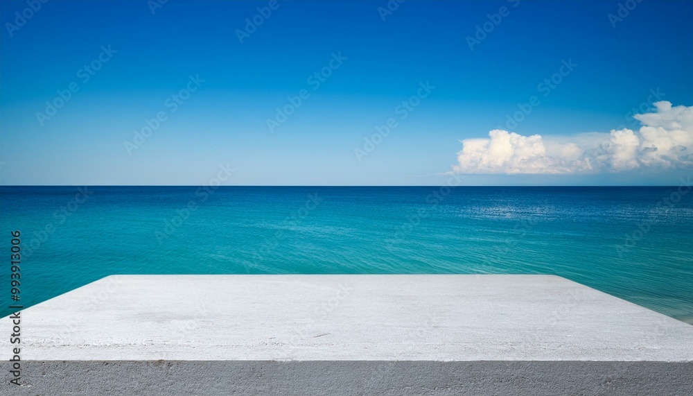 Fototapeta premium Concrete table top against the background of the sea on the beach. Empty white countertop for product presentation with blue water and sky. Outdoor mockup