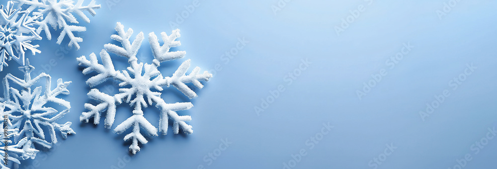 Delicate snowflakes resting on a soft blue background during winter, capturing the essence of a serene cold season. Delicate snowflakes resting on a soft blue background during winter, capturing the essence of a serene cold season.