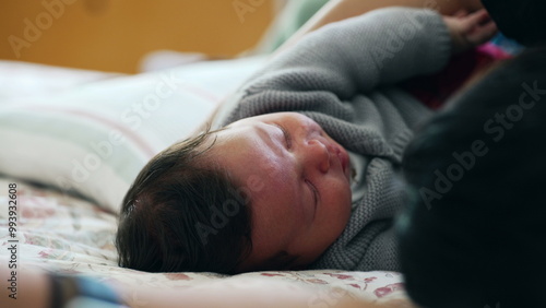 Baby sleeping peacefully on a cozy bed, wearing a warm sweater, embodying tranquility and comfort in a safe and loving home environment, showcasing serene restfulness