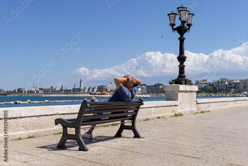 Obraz na płótnie Man resting on a bench at Emperor Augustus seafront (Lungomare Imperatore Augusto), promenade by Adriatic Sea, Bari, Italy, Apulia w salonie